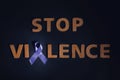 Purple awareness ribbon and phrase STOP VIOLENCE made of wooden letters on black background Royalty Free Stock Photo