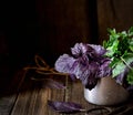Purple basil and parsley in a cup on a wooden background