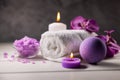 purple bath bomb, sea salt crystals, towel and scented candles on wooden table. body skin care Royalty Free Stock Photo