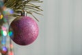 Purple bauble hanging on a decorated Christmas tree. Christmas backgroung