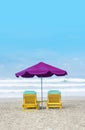 Purple Beach Umbrella With Yellow Lazy Wooden Chair on The Bali Beach During Summer Vacation Royalty Free Stock Photo