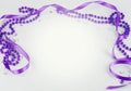 Purple beads and ribbon and sparkly jewels on a light background make a border for International Women`s Day on March 8th each Royalty Free Stock Photo