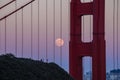 Full moon visible through the cables of the San Francisco Golden Gate Bridge