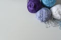 Purple, blue and white yarn balls, for hand knitting on a white background with copy space. Royalty Free Stock Photo
