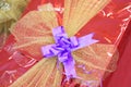 Purple bow on a golden net covered gift pack Royalty Free Stock Photo