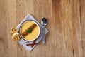 Ceramic bowl of pumpkin soup on napkin over rustic wooden background, close-up, selective focus, top view. Royalty Free Stock Photo