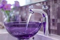 A Purple Bowl Filled with Water Beneath a Shiny Chrome Faucet. Concept Still Life Photography,