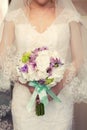 Purple bridal bouquet in the hands of