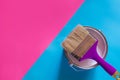 Purple brush with open can of white paint on blue and pink neon background. Trend concept Royalty Free Stock Photo