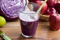 Purple cabbage juice in a glass, with cabbage in the background Royalty Free Stock Photo
