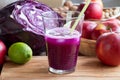 Purple cabbage juice in a glass, with cabbage and apples in the Royalty Free Stock Photo