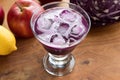 Purple cabbage juice with ice cubes in a glass on a wooden table Royalty Free Stock Photo