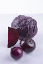 Purple cabbage, onions, beetroot on purple and white