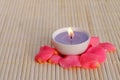 Purple candle with rose petals