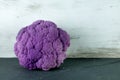 Purple cauliflower lying on a gray slate plate Royalty Free Stock Photo