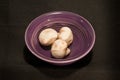 purple, ceramic bowl with three, freshly picked, white mushrooms Royalty Free Stock Photo