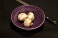 purple, ceramic bowl with two shallots Royalty Free Stock Photo