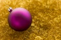 Purple christmas ball on gold glitter Royalty Free Stock Photo