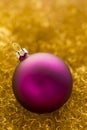 Purple christmas ball on gold glitter Royalty Free Stock Photo