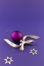 Purple christmas ball with stars and grey ribbon Royalty Free Stock Photo