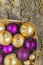 purple Christmas balls and gold, beads lie in a wooden basket to Royalty Free Stock Photo
