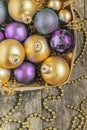 purple Christmas balls and gold, beads lie in a wooden basket to Royalty Free Stock Photo