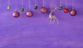 Purple christmas balls hanging on purple  background.Christmas template with large copy space.Negative space technique Royalty Free Stock Photo