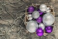 purple Christmas balls and silver, beads lie in a wooden basket Royalty Free Stock Photo