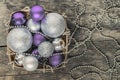 purple Christmas balls and silver, beads lie in a wooden basket Royalty Free Stock Photo