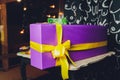 Purple Christmas package gift silver ribbon Jingle bells silver balls and christmas stars put on snow. Royalty Free Stock Photo