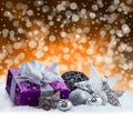 Purple Christmas package , gift of a silver ribbon. Jingle bells , silver christmas balls and christmas stars put on snow. Royalty Free Stock Photo