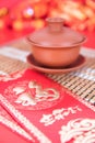 Purple Clay Gaiwan and New Year Red Packets on Red Background.The Chinese characters in the picture mean `happiness` and `good luc