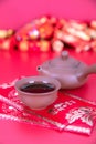 Purple Clay Tea Set and New Year Red Packets on Red Background.The Chinese characters in the picture mean `happiness`