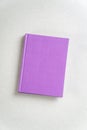 Purple closed notebook on gray top view