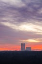 Purple clouds in dawn sky over park and towers Royalty Free Stock Photo