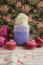 Purple coffee in stylized mason jar cup with macarons and roses and colorful decoration on background of floral pattern. Blueberry Royalty Free Stock Photo