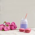 Purple coffee in stylized mason jar cup with macarons and roses and colorful decoration. Blueberry milk shake. Royalty Free Stock Photo