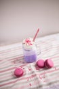 Purple coffee in stylized mason jar cup with macarons and roses and colorful decoration. Blueberry milk shake. Unicorn coffee. Royalty Free Stock Photo