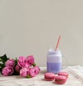 Purple coffee in stylized mason jar cup with macarons and roses and colorful decoration. Blueberry milk shake. Unicorn coffee. Royalty Free Stock Photo