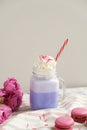 Purple coffee in stylized mason jar cup with macarons and roses and colorful decoration. Blueberry milk shake. Unicorn coffee. Royalty Free Stock Photo