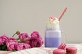 Purple coffee in stylized mason jar cup with macarons and roses and colorful decoration. Blueberry milk shake. Unicorn coffee. Royalty Free Stock Photo