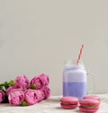 Purple coffee in stylized mason jar cup with macarons and roses and colorful decoration. Blueberry milk shake. Unicorn coffee. Royalty Free Stock Photo