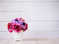 Purple colored artificial rose flowers bouquet in pot on table, Royalty Free Stock Photo