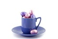 Purple cup and saucer filled with chocolate Easter eggs Royalty Free Stock Photo