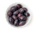 Purple damson plums in bowl top view isolated Royalty Free Stock Photo