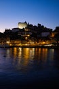 Purple dark sunset landscape scene in the shore of the Douro river in Oporto, Portugal with urban skyline