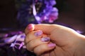 Purple design of nails with patterns of flowers and ribbon. Royalty Free Stock Photo