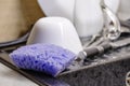 Purple dishwashing sponge lies on sink, clean dishes against background