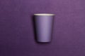 A purple disposable cup on a purple background