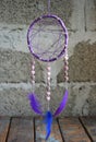 Purple dream catcher on grey background. Dreamcatcher decoration accessory for bedroom, closeup photo. Workshop, hobby, handicraft